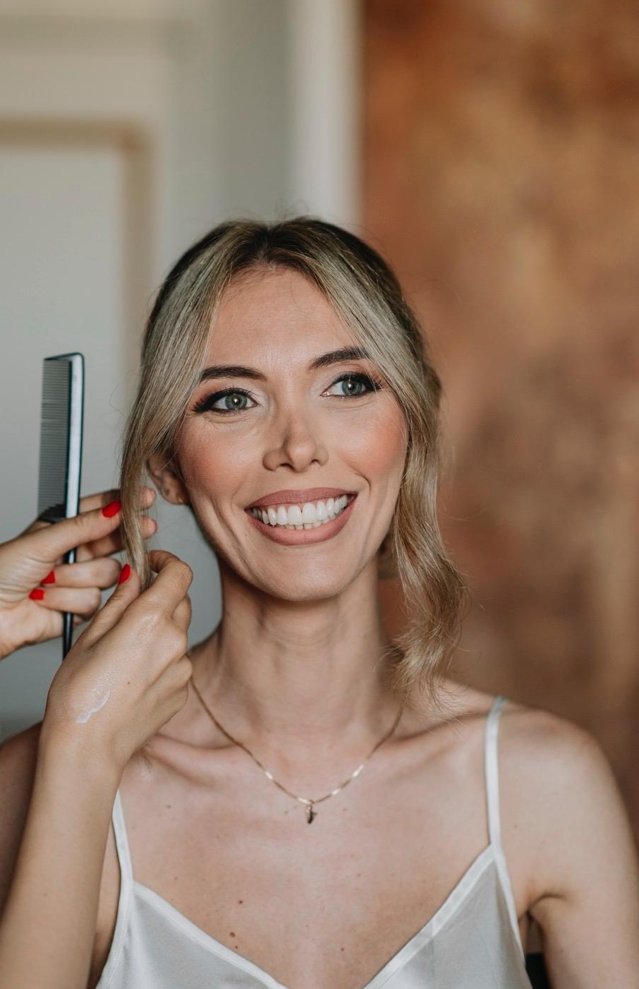 Francesca rifinisce l'acconciatura di una cliente sorridente